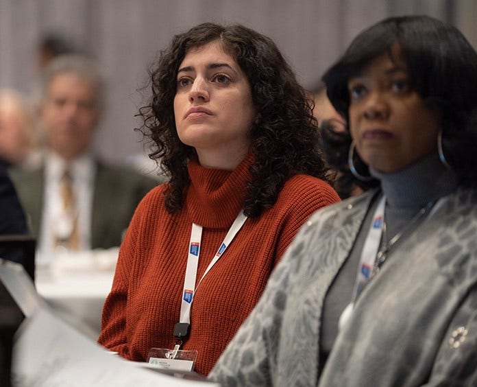 black and white woman listening to a speaker during roundtables session