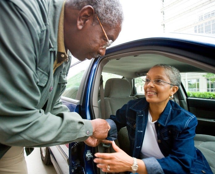 man helping woman out of car