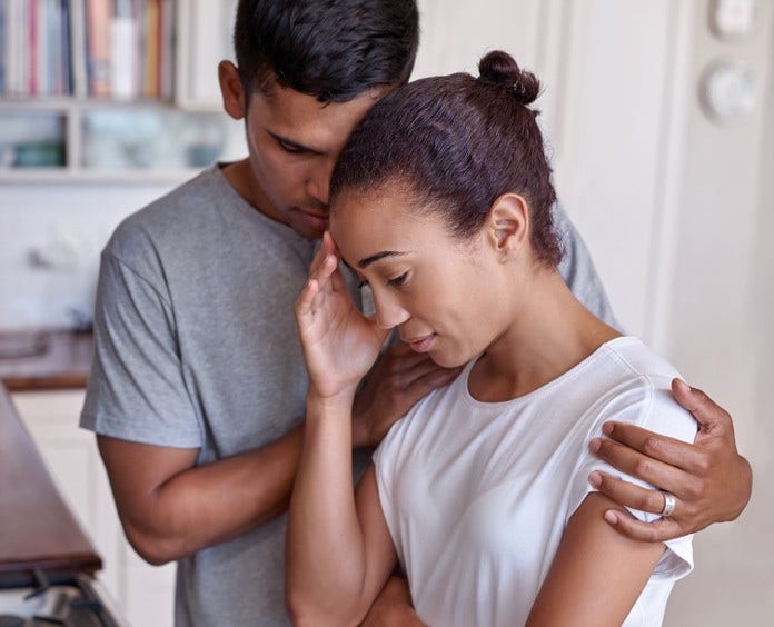 man comforting stressed woman