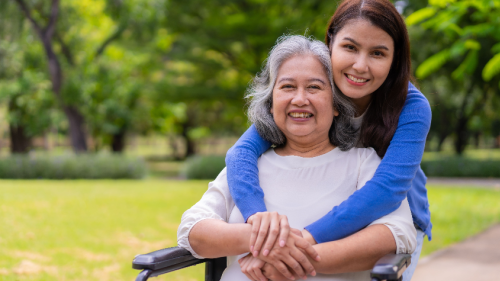 Female caregiver or nurse taking care of the patient in a wheelchair.