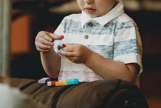 boy playing with rainbow lego blocks