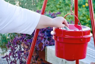 hand putting money in bucket