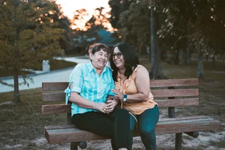 women sitting on a park bench