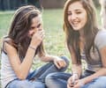 Three girls siting on the grass outdoors