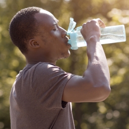 man drinking water from a reusable water bottle