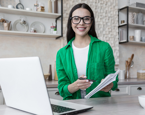 Young woman in kitchen learning online