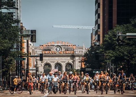 Photo of cyclists riding in 17th with Denver's Union Station in the background
