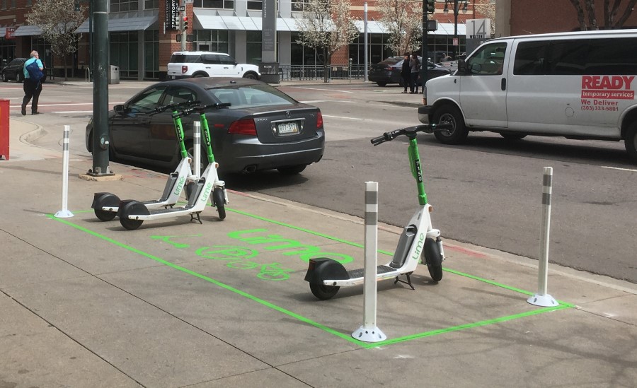 Photo of Lime scooters parked inside a Lime sidewalk scooter station