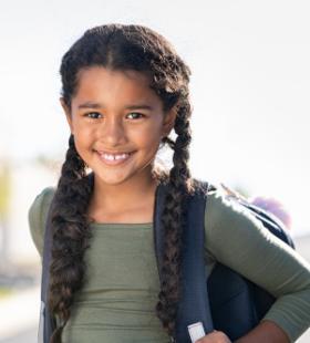 Elmentary schoolgirl carrying backpack