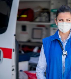 Masked woman by ambulance