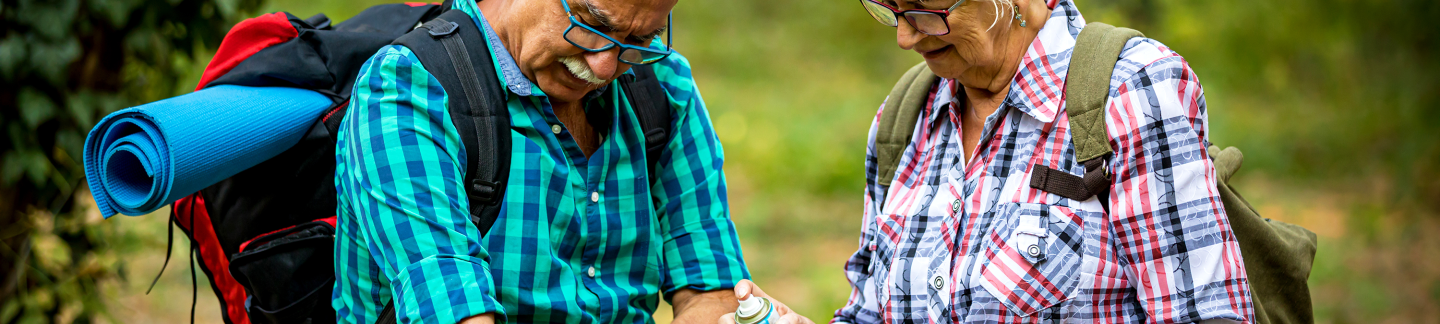 Una pareja mayor al aire libre usando repelente de mosquitos