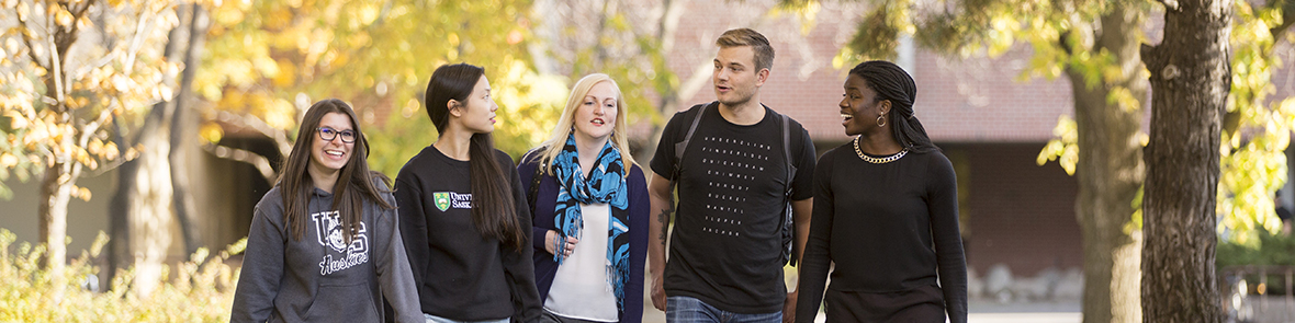 Five students walking and having a discussion