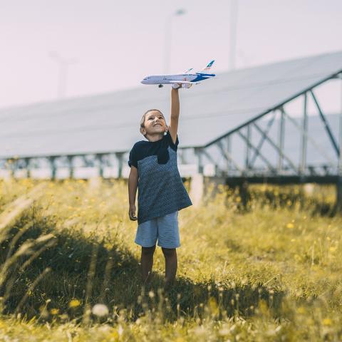 boy flying a plane outside