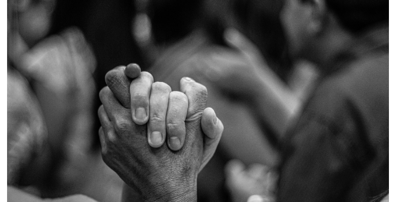 Black and white picture of two people holding hands