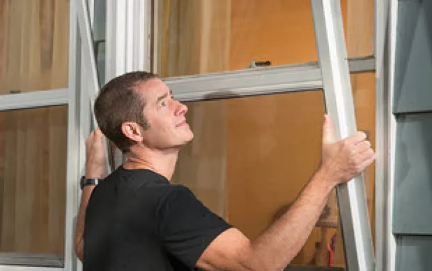 man installing storm windows