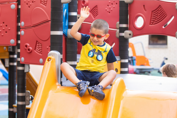 image of a boy on a playground wearing glasses.