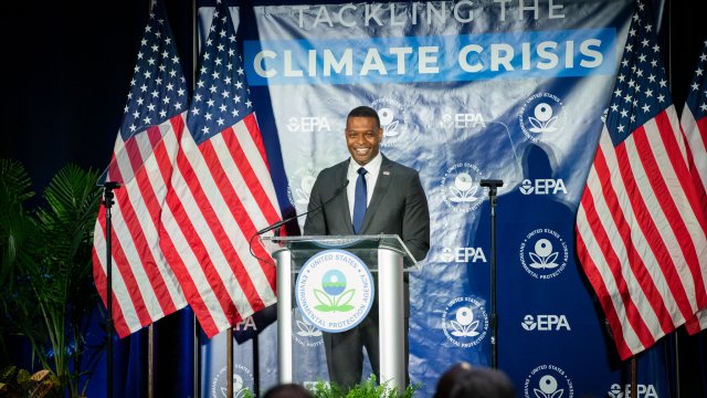 Administrator Regan at the podium with a Climate Crisis banner in the background and American flags on either side