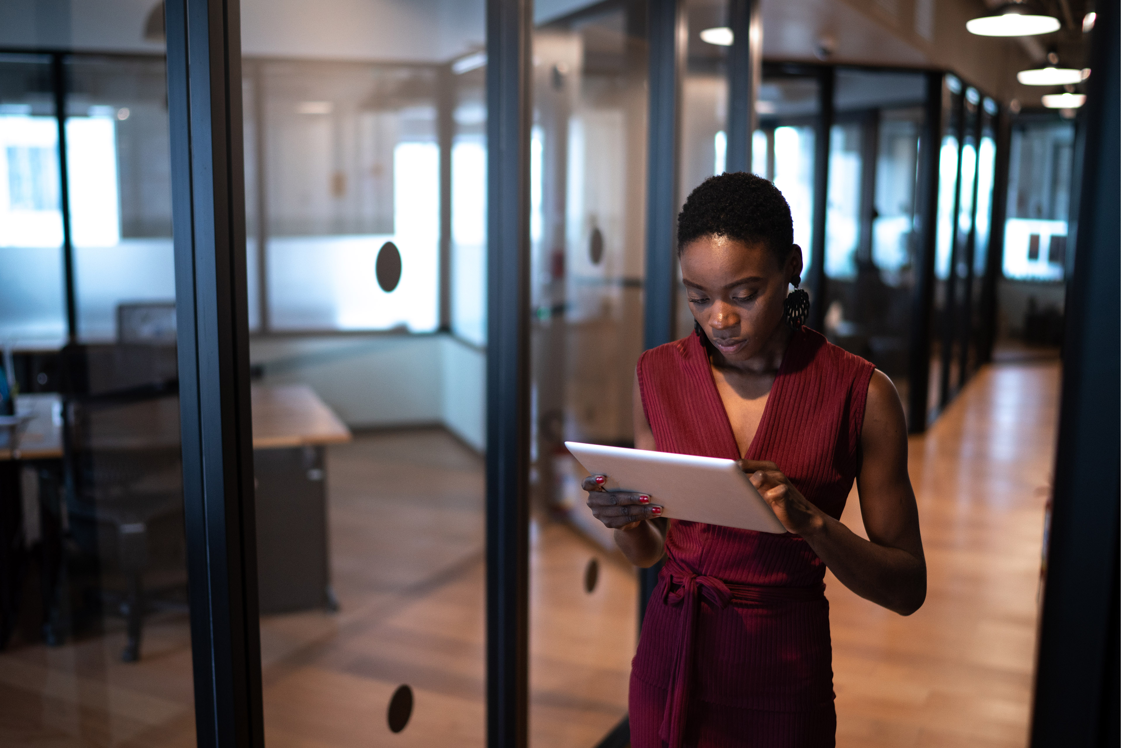 Young business woman walking with digital tablet at coworking