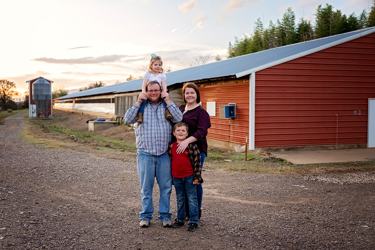 Four people standing in front a barn