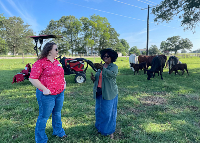 Two people talking while standing in a pasture