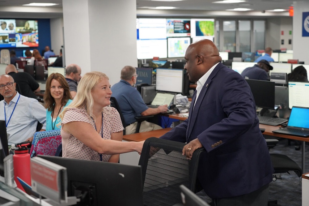 Man in suit shaking a young woman's hand in the office.