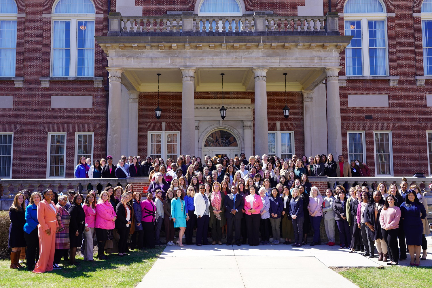 Large group of people standing on the outdoor steps of a building.