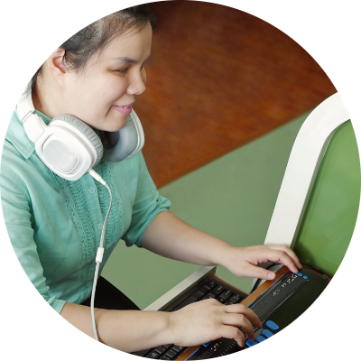 Woman wearing headphones at a computer