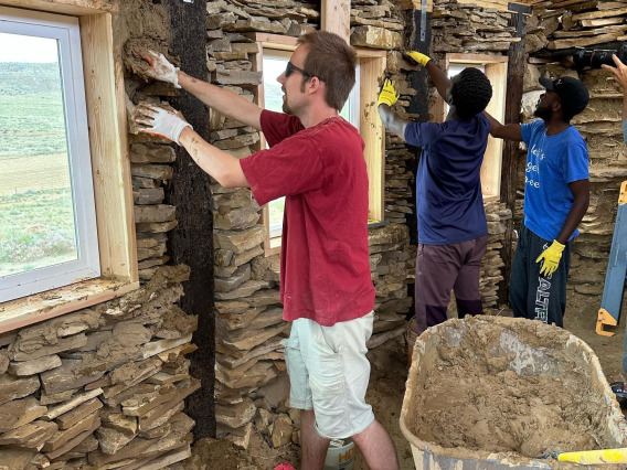 CIELO participants mudding the walls of passive solar house