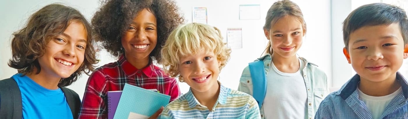 A group of children in a classroom smiling