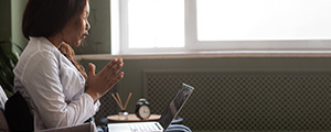 Adult female talking to a doctor virtually using a laptop computer.