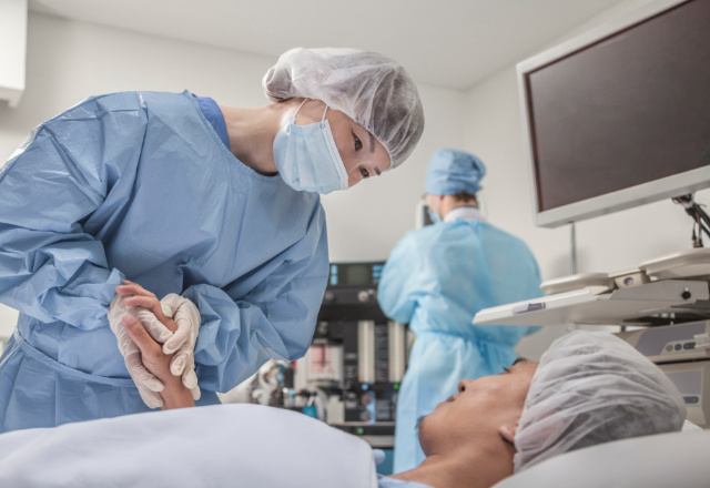 surgeon holding patient's hand - heart and vascular institute