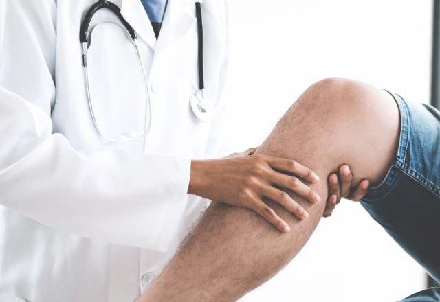 doctor examining patient's leg - heart and vascular institute