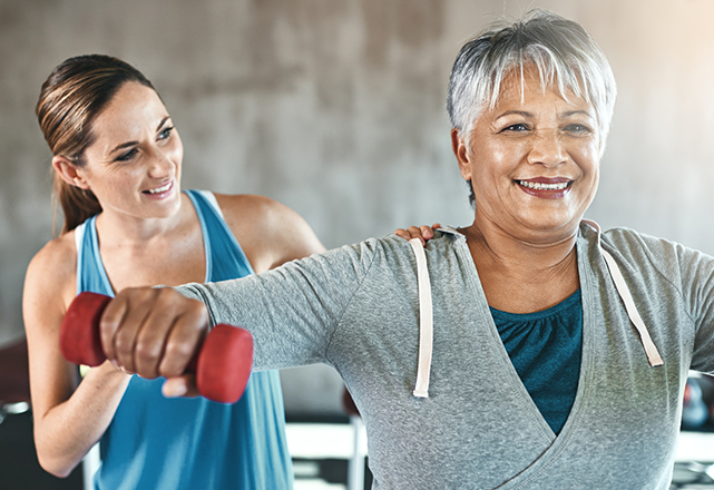 doctor supervising patient lifting weight - heart and vascular institute