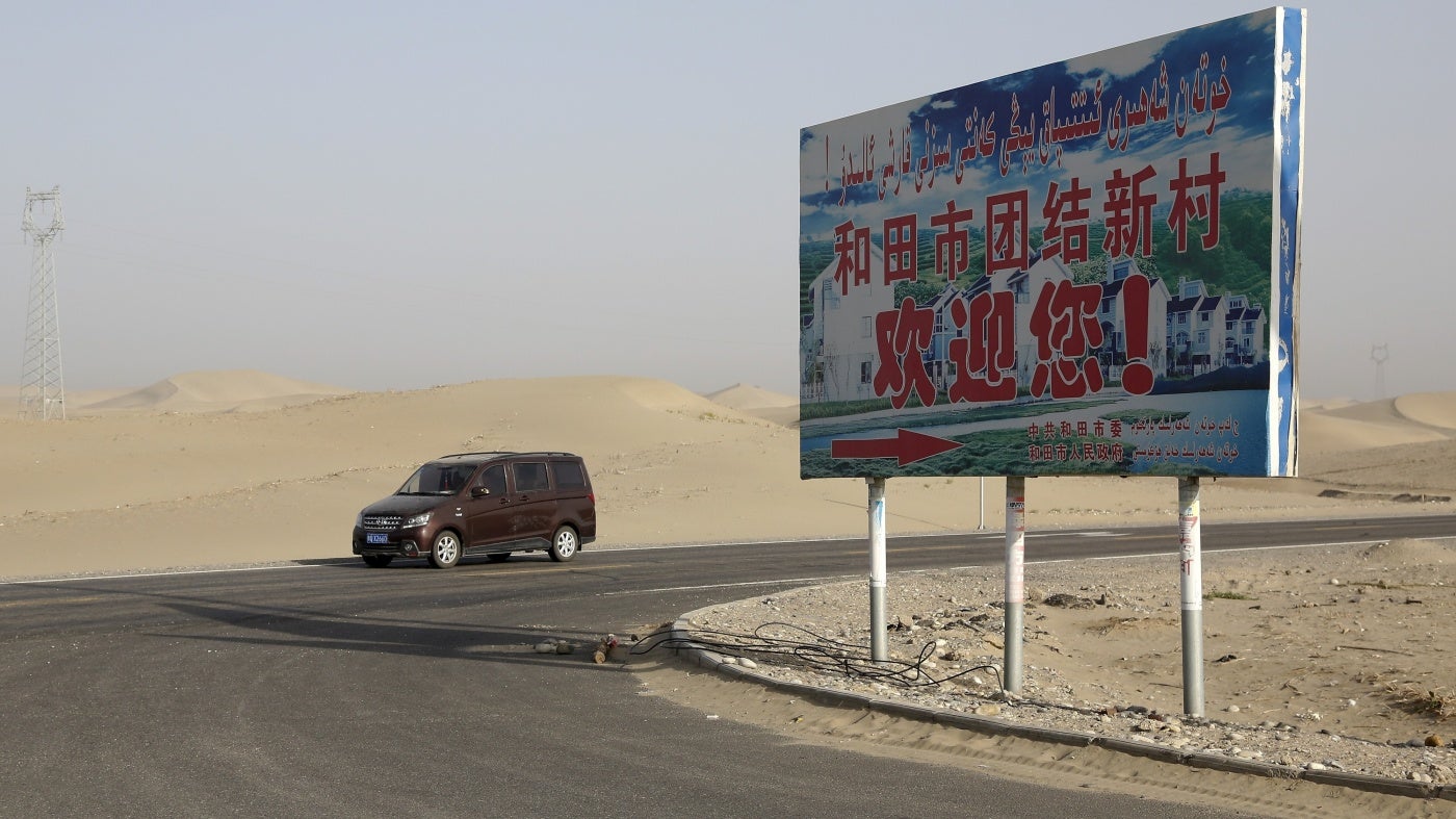 A signboard reads "Welcome to Hotan Unity New Village" in Hotan, Xinjiang, September 21, 2018. 