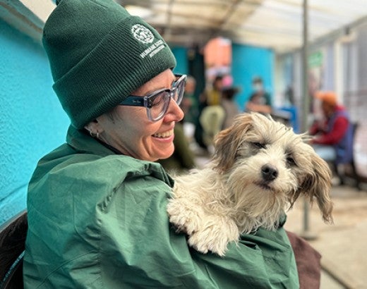 Woman smiling and holding dog