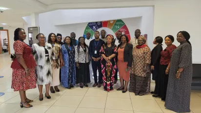 Stakeholders post in front of a UN SDGs banner