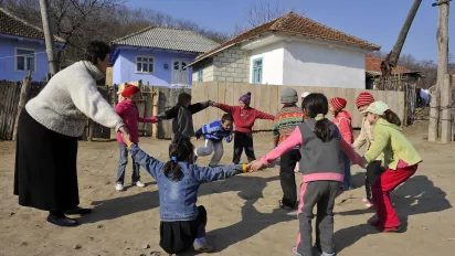 Children playing with their teacher in a school playground