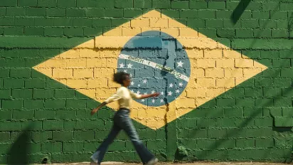 Girl walking down the street with Brazilian flag on wall