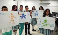Foto grupas de jóvenes estudiantes de un colegio sosteniendo pancartas con los logos dibujados del SENA y OIT