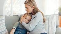 Shot of a young mother comforting her daughter on the sofa at home