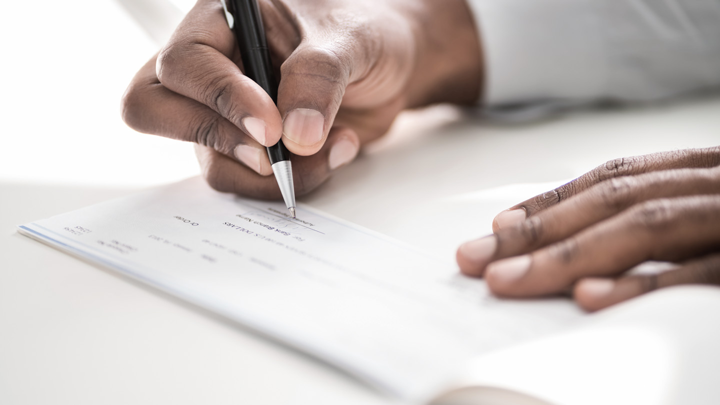 Man signing a paper check