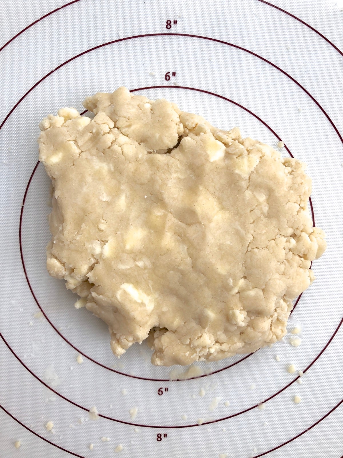 Pie pastry on a floured silicone mat, ready to divide.