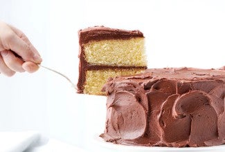 Slice being lifted from chocolate-frosted yellow cake