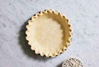 Pie crust rolled out, docked, crimped, in the pan and ready to be filled.