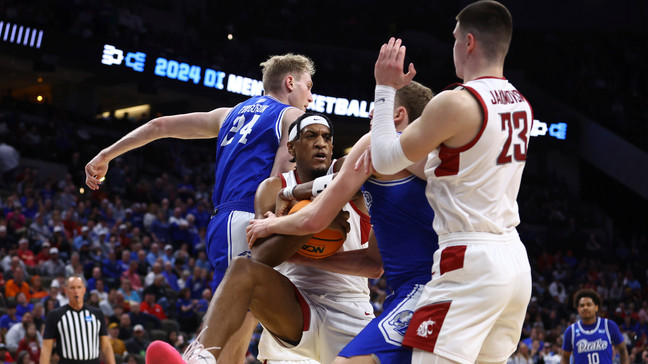 Washington State's Isaac Jones (13) pulls in a ball as teammate Andrej Jakimovski (23) watches and Drake's Nate Ferguson (24) defends during the first half of a first-round college basketball game in the NCAA Tournament Thursday, March 21, 2024, in Omaha, Neb. (AP Photo/John Peterson)