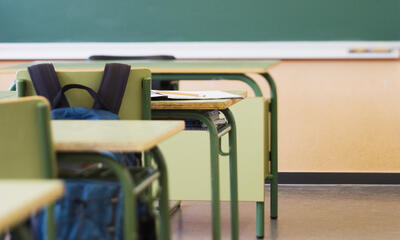 paper and pencil on desk in classroom