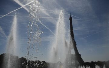 A photograph shows jets of water by the Trocadero fountains near to the Eiffel Tower, amid high temperatures in Paris on June 16, 2022. France is set to experience record-breaking temperatures nearing 40C in June, as a forecasted heatwave to hit a large part of the country. (Photo by JULIEN DE ROSA / AFP)