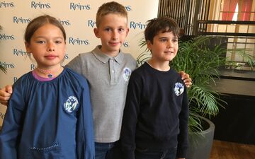 Romane en CE2 à l'école Mazarin, Aurèle et Victor en CM1 à l'école Voltaire jouent les modèles  pour la présentation de l'uniforme de Reims orné d'un écusson imaginé par les écoliers eux-mêmes. LP/Marie Blanchardon