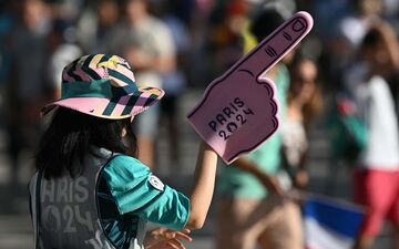 Les volontaires des JO 2024 recrutés par la ville de Paris, qui guident les spectateurs vers les sites olympiques, sont reconnaissables à leur tenue vert turquoise. AFP/Oli Scarff