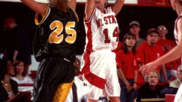 Two basketball players shooting and blocking a ball